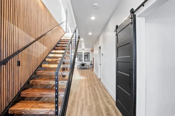 Wood-finish flooring throughout, complemented by a contemporary staircase with wood treads and cable railing