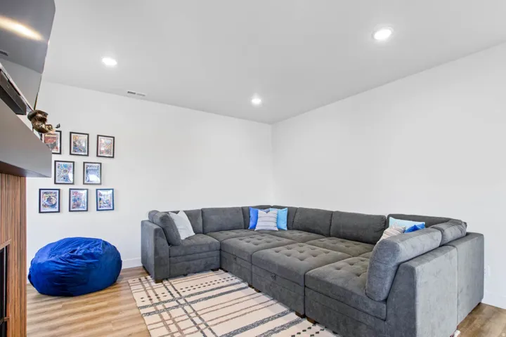 Recessed lighting illuminates this space featuring wood-finish flooring and white walls