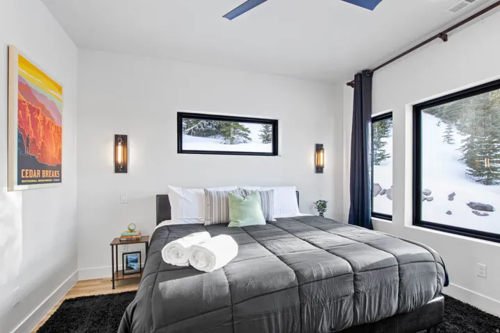 Recessed lighting, wood-finish flooring, multiple windows, built-in wall sconces, and a ceiling fan