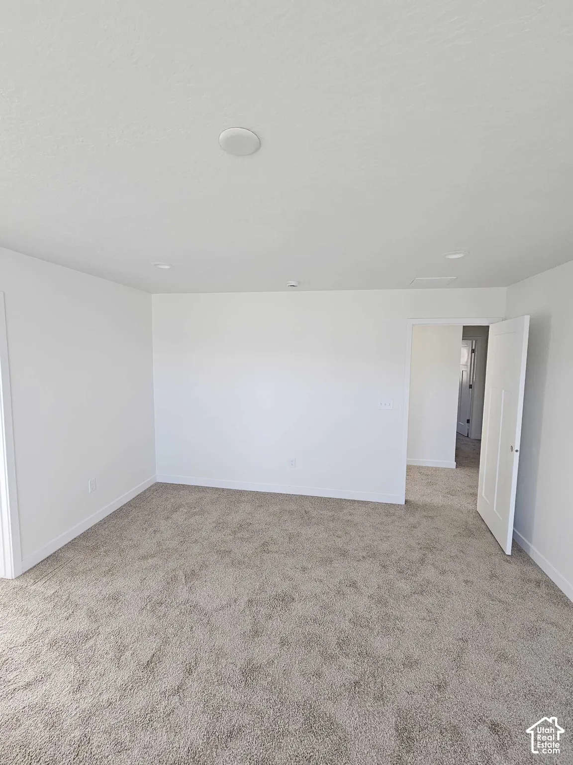 Recessed ceiling lighting and a neutral carpeted floor