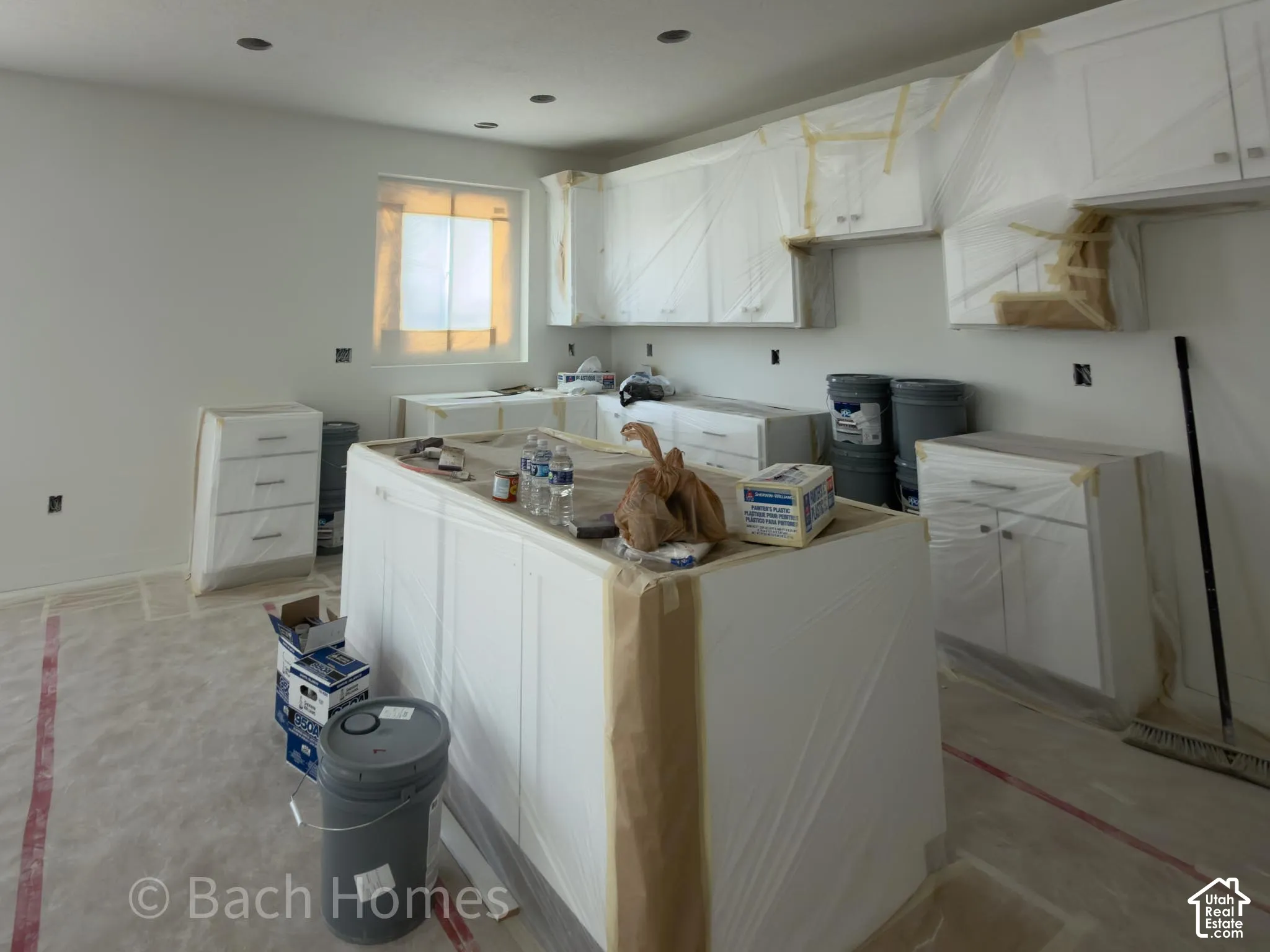 Recessed lighting, white cabinetry, a kitchen island, and a window