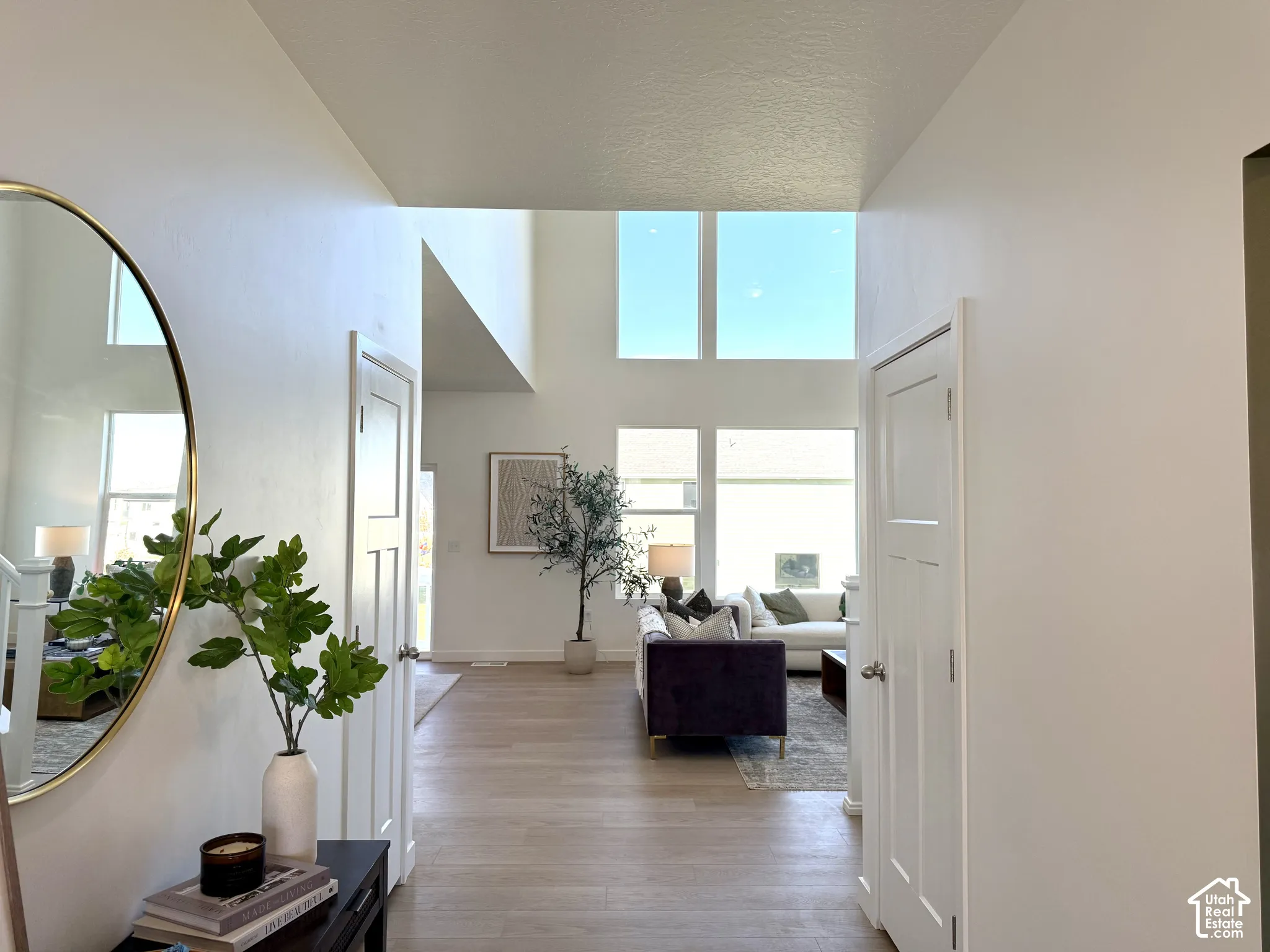 High ceilings with natural light, wood-finish flooring, and white interior doors