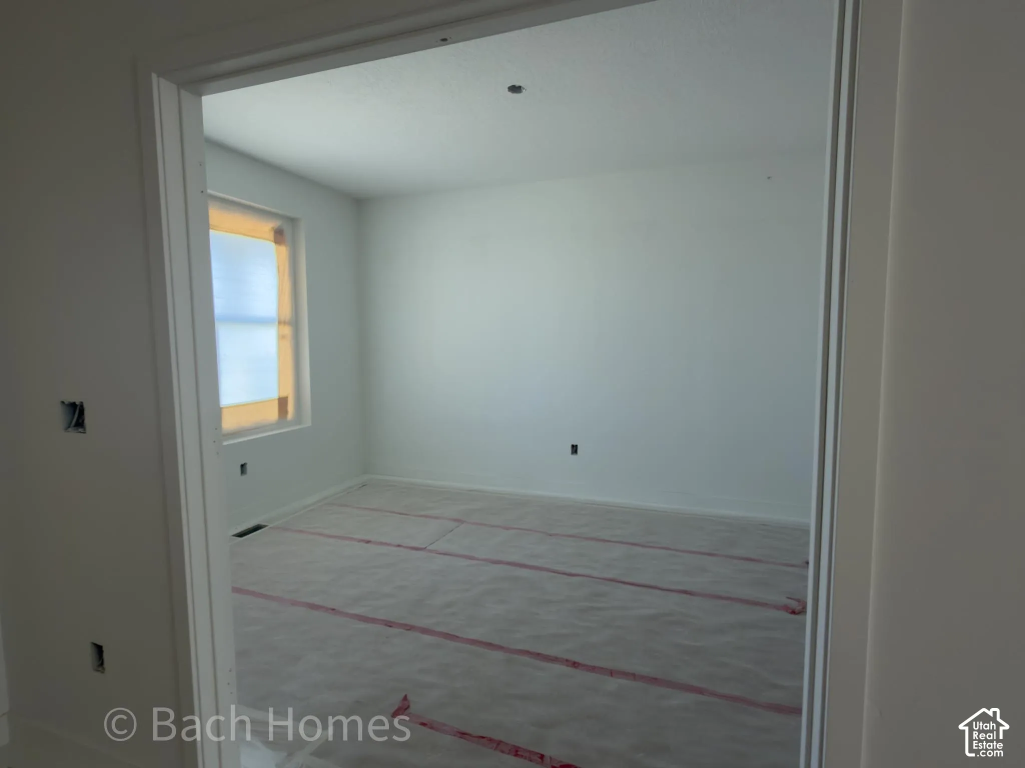 Open doorway leading into a room with a window featuring natural light