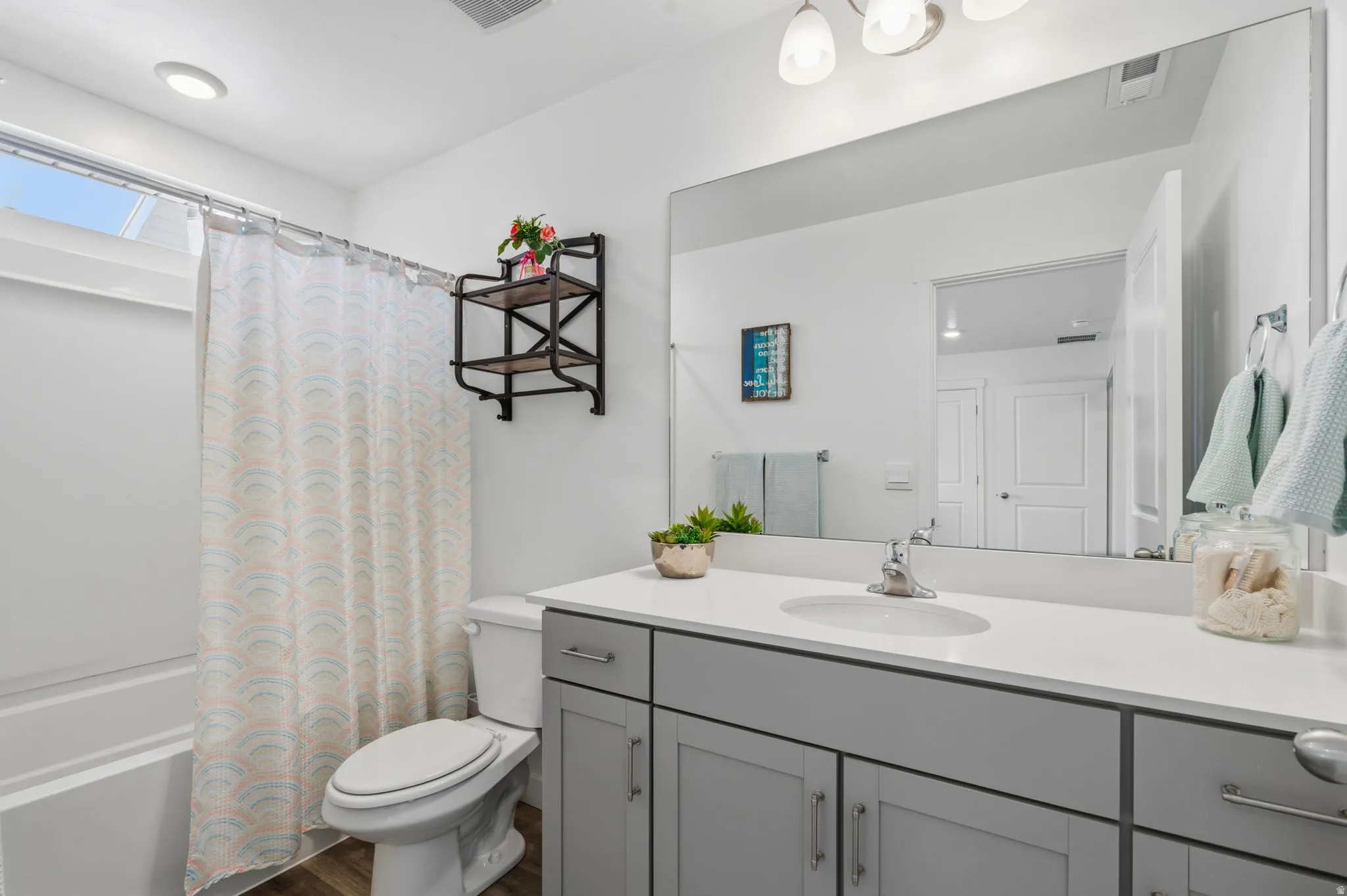 Modern vanity with dual-door cabinetry, a single basin sink, and a large wall-mounted mirror