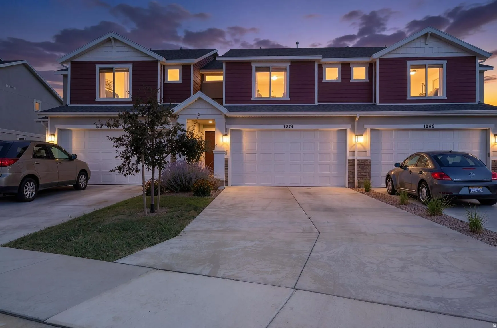 Siding exterior with white trim, multiple garage spaces, concrete driveway, and front landscaping