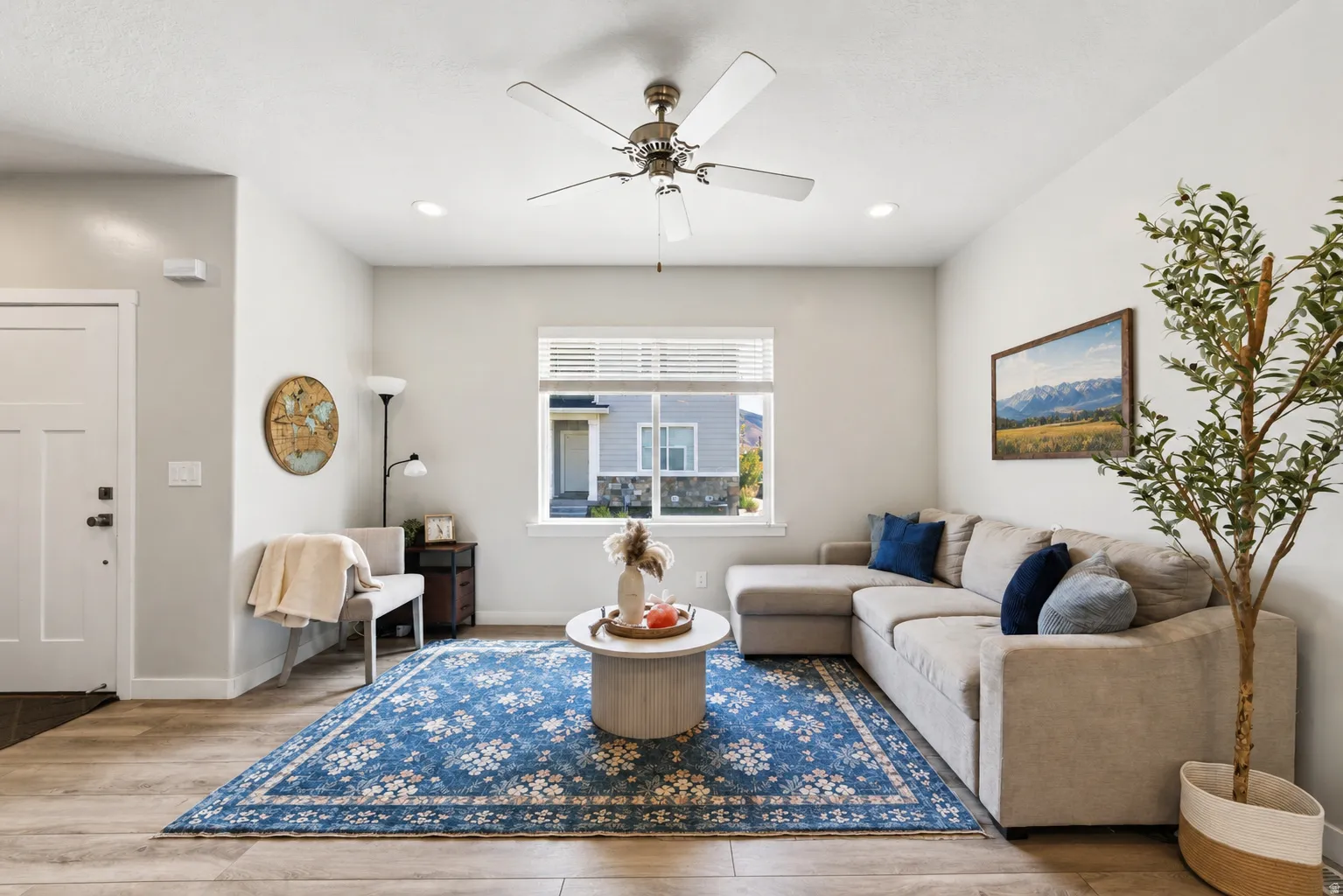 Recessed lighting, wood-finish flooring, ceiling fan, white trim, and a multi-pane window