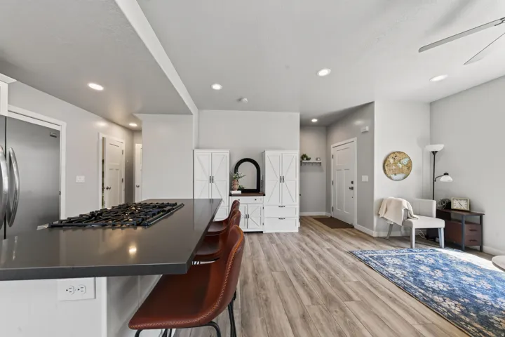 Kitchen island with a dark countertop and integrated cooktop, complemented by stainless steel appliances