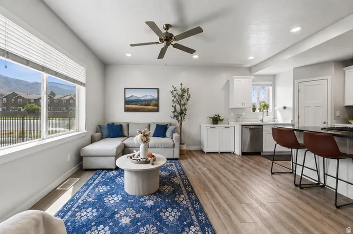 Open-concept living space featuring wood-finish flooring, recessed lighting, and a ceiling fan