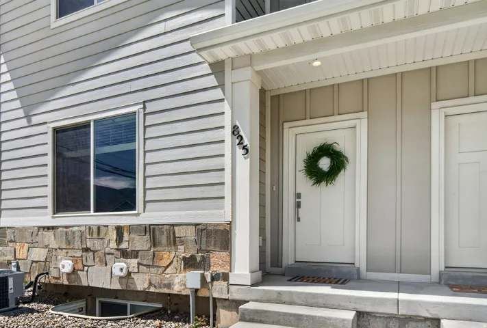 Exterior featuring horizontal siding, stone veneer foundation, and a covered entry with recessed lighting