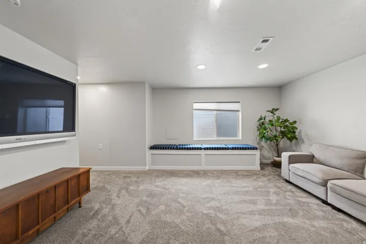 Recessed lighting illuminates the carpeted floor and built-in window bench