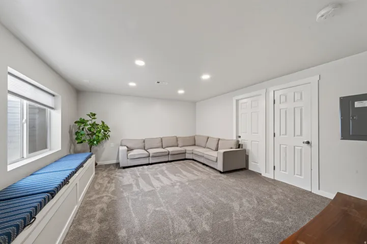 Recessed lighting illuminates this space featuring gray carpeting