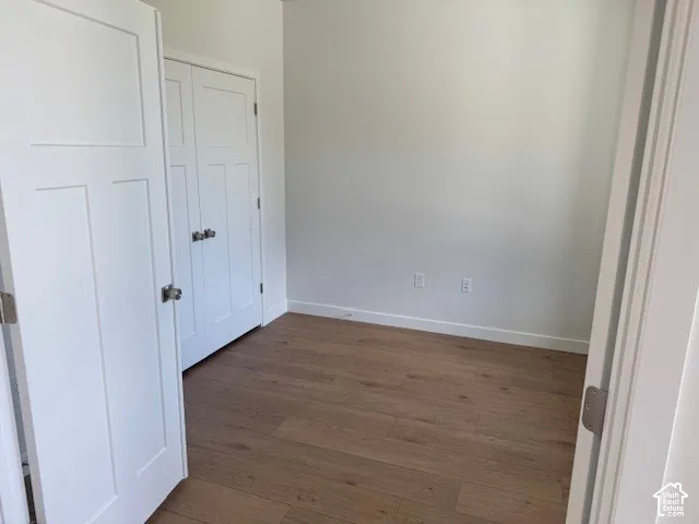 Wood-finish flooring, white paneled doors, and a built-in closet with brushed nickel hardware