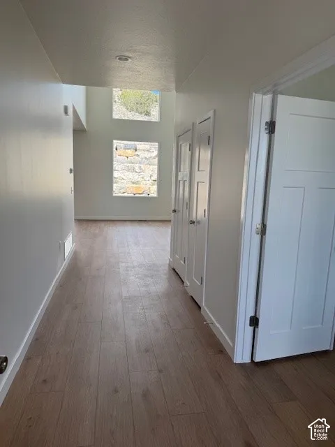 Wood-finish flooring throughout, bright white walls, and recessed lighting
