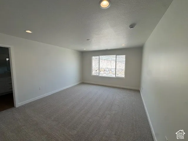 Neutral tone walls, recessed lighting, and a large window