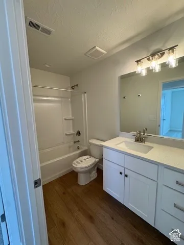 White shaker-style vanity with a light-toned countertop, integrated sink, and brushed nickel fixtures