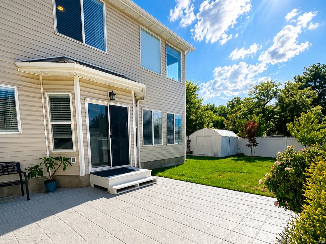 Exterior vinyl siding, a concrete patio with a wood-grain pattern, and a well-maintained lawn