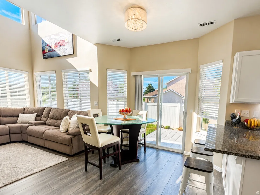 Wood-finish flooring throughout, complemented by a two-story ceiling and ample natural light from multiple windows