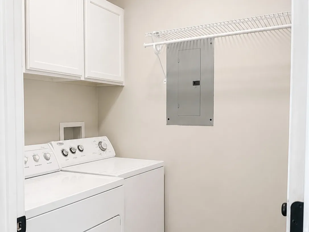 White upper cabinetry, permanent wire shelving, and wood-finish flooring