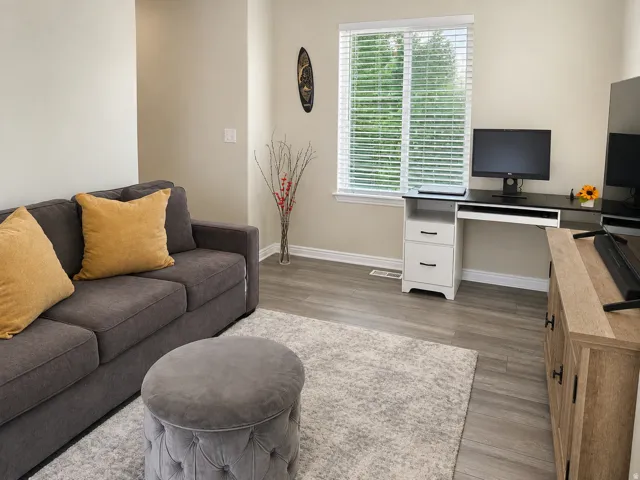Recessed window with horizontal blinds, wood-finish flooring, light-toned wall paint, and white trim