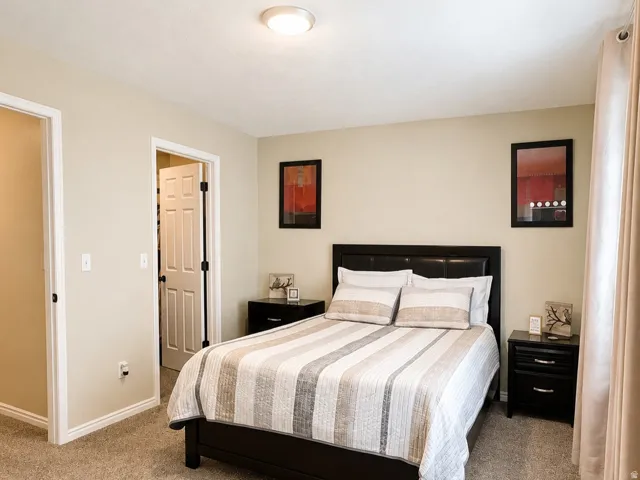 Neutral-toned walls complement the soft, textured carpeting