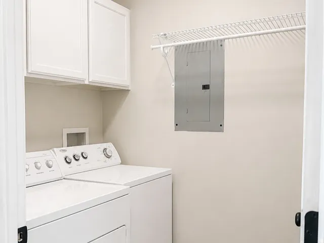 White upper cabinetry, permanent wire shelving, and wood-finish flooring