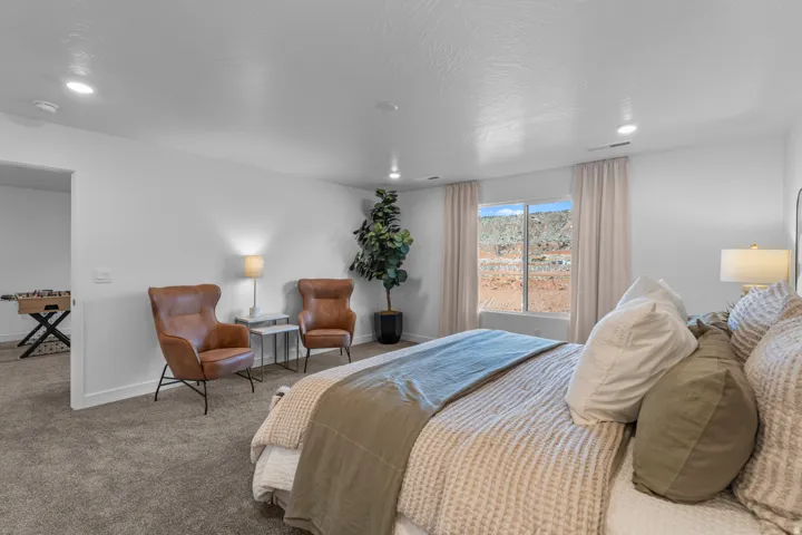 Recessed lighting, large window, carpeted flooring, and an open doorway to an additional space