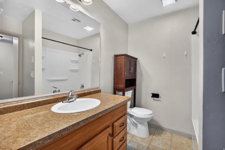 Integrated vanity with an oval sink, chrome faucet, and expansive wall mirror