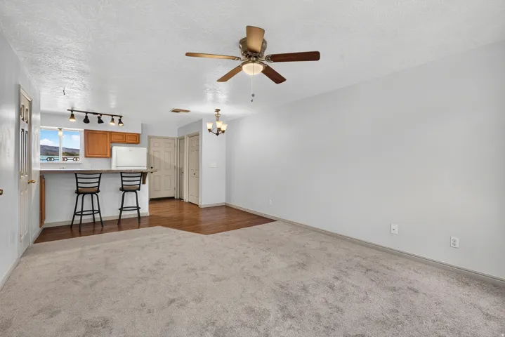 Bright interior with ceiling fan, track lighting, and a breakfast bar