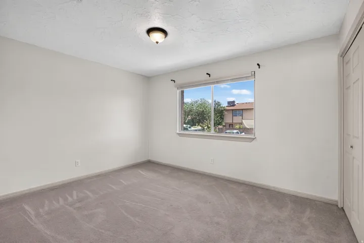 Recessed window with exterior scenery, overhead light fixture, carpeted flooring, and a bi-fold door