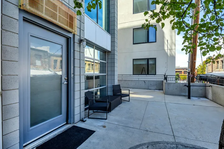 Concrete patio with block wall exterior and full-light entry door