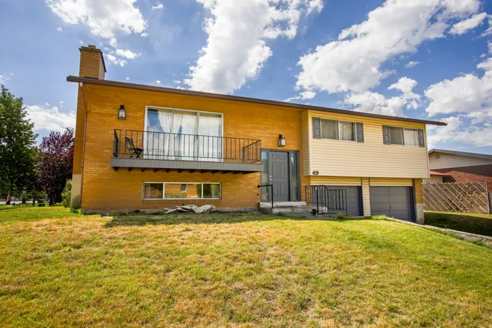 Brick and siding exterior with a balcony and two-car garage