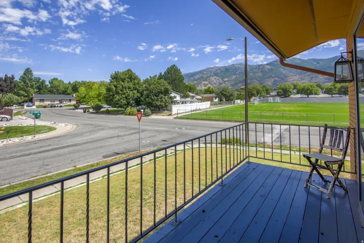 Porch with painted wood flooring and black metal railing