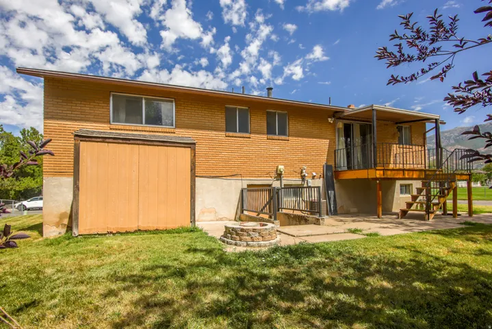 Brick exterior featuring a wood deck with metal railings and steps