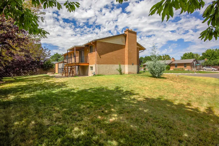 Brick exterior with a two-story deck, featuring a wood-finish railing and stairs