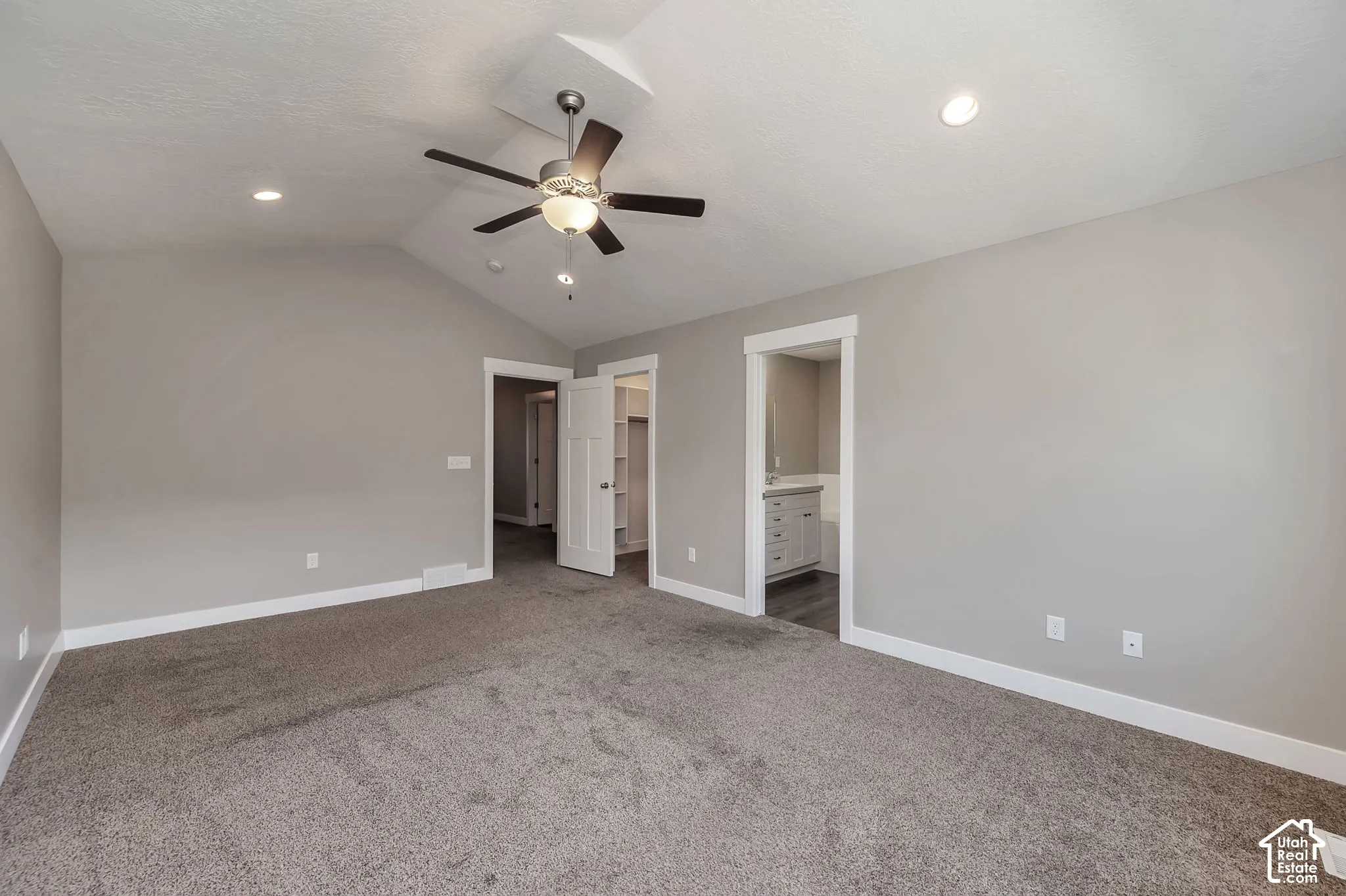 Vaulted ceiling with a ceiling fan, recessed lighting, carpet flooring, and white trim