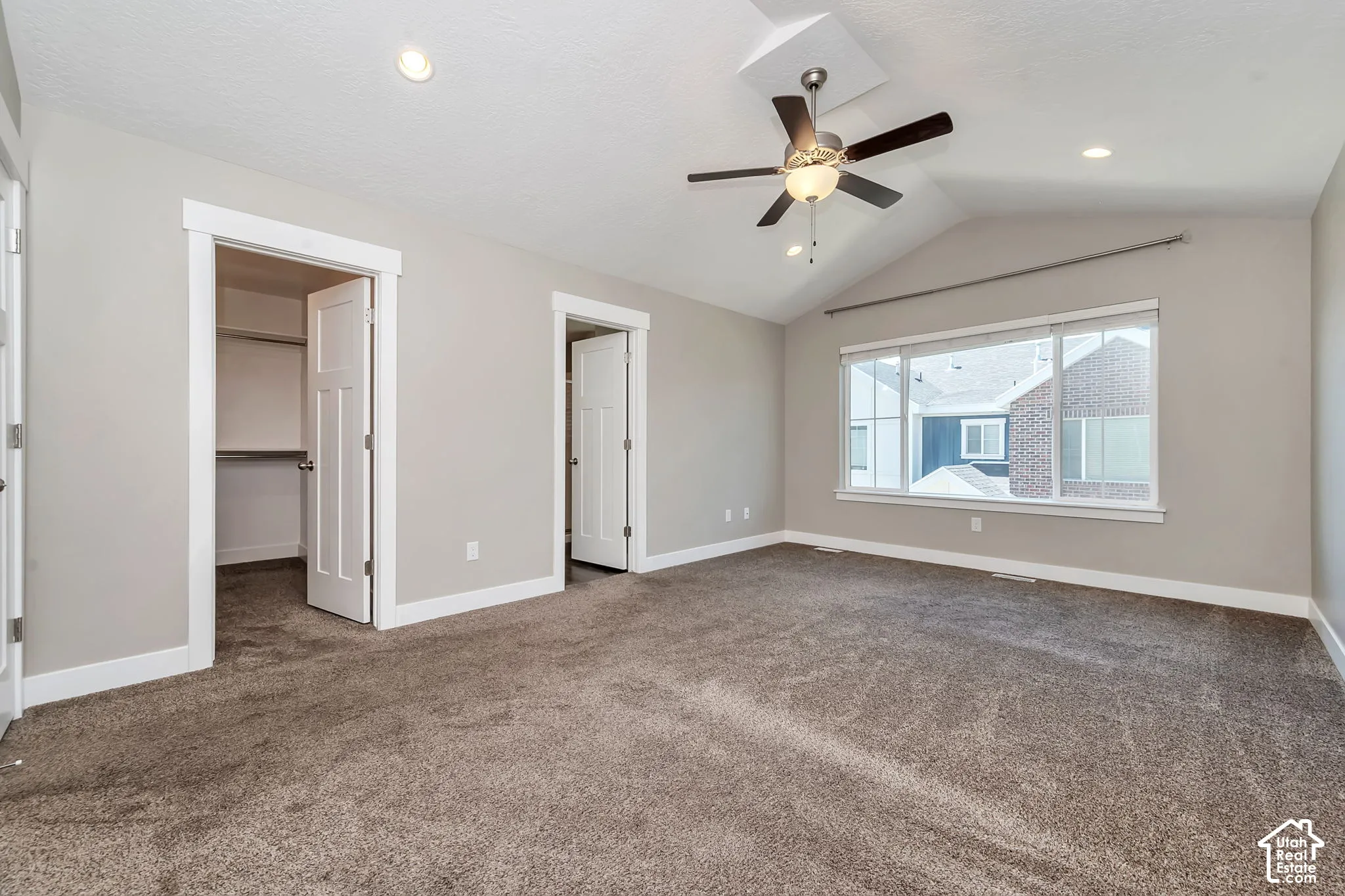Vaulted ceiling with a ceiling fan, recessed lighting, carpeted flooring, and a large window