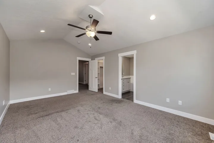 Vaulted ceiling with a ceiling fan, recessed lighting, carpet flooring, and white trim