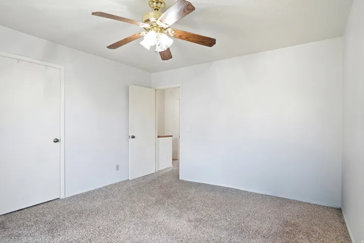 Neutral wall tones with a textured ceiling and a ceiling fan with integrated lighting