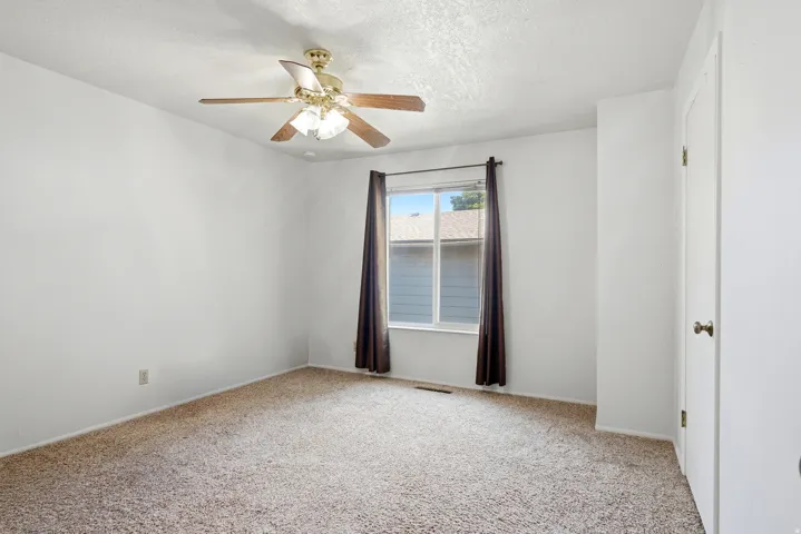 Neutral-toned wall paint with a window featuring brown drapery