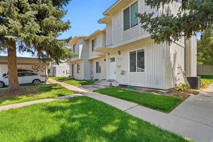 Multi-unit property featuring vertical siding and decorative paneling