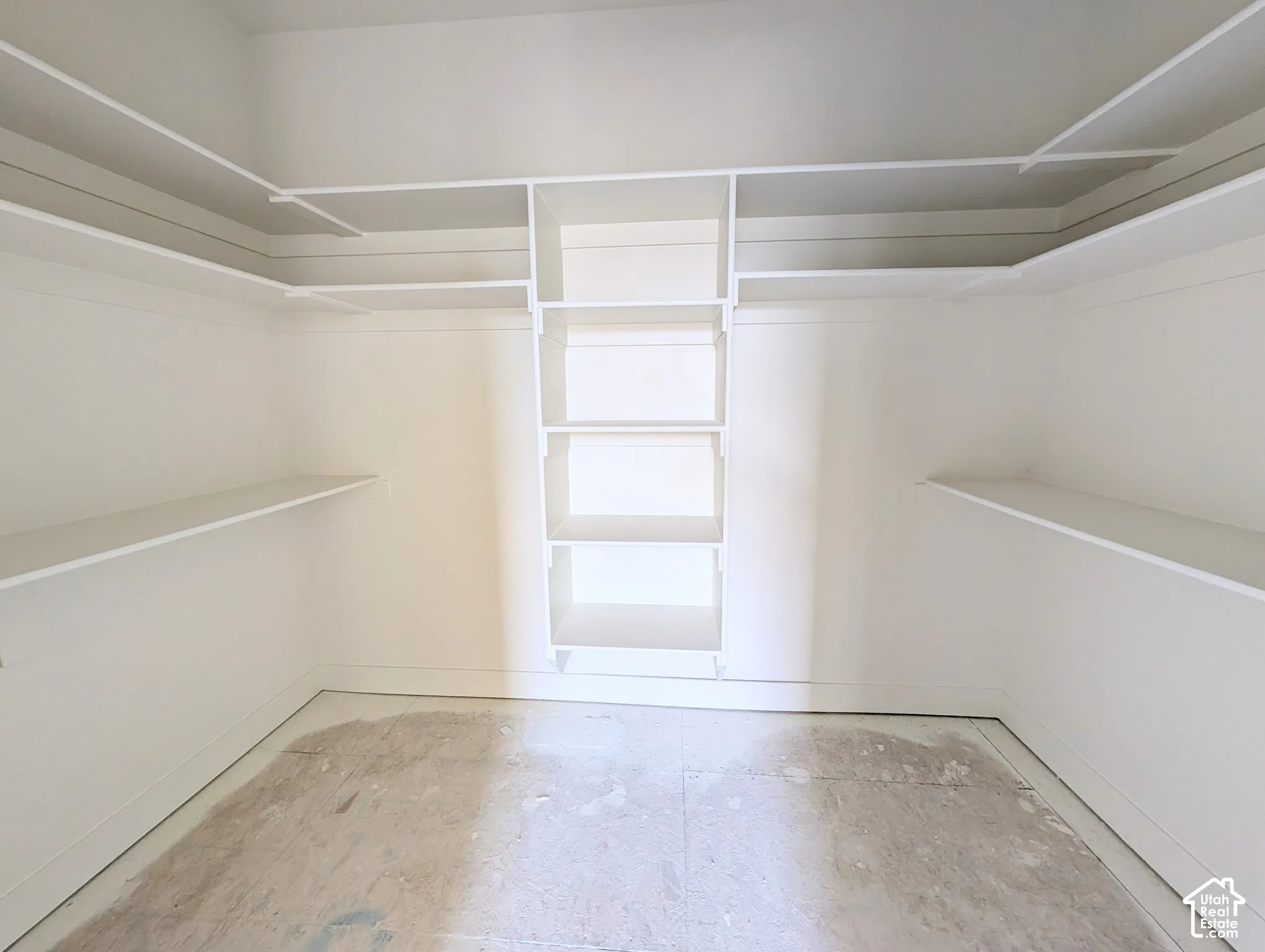 Walk-in closet featuring extensive built-in shelving and hanging rods