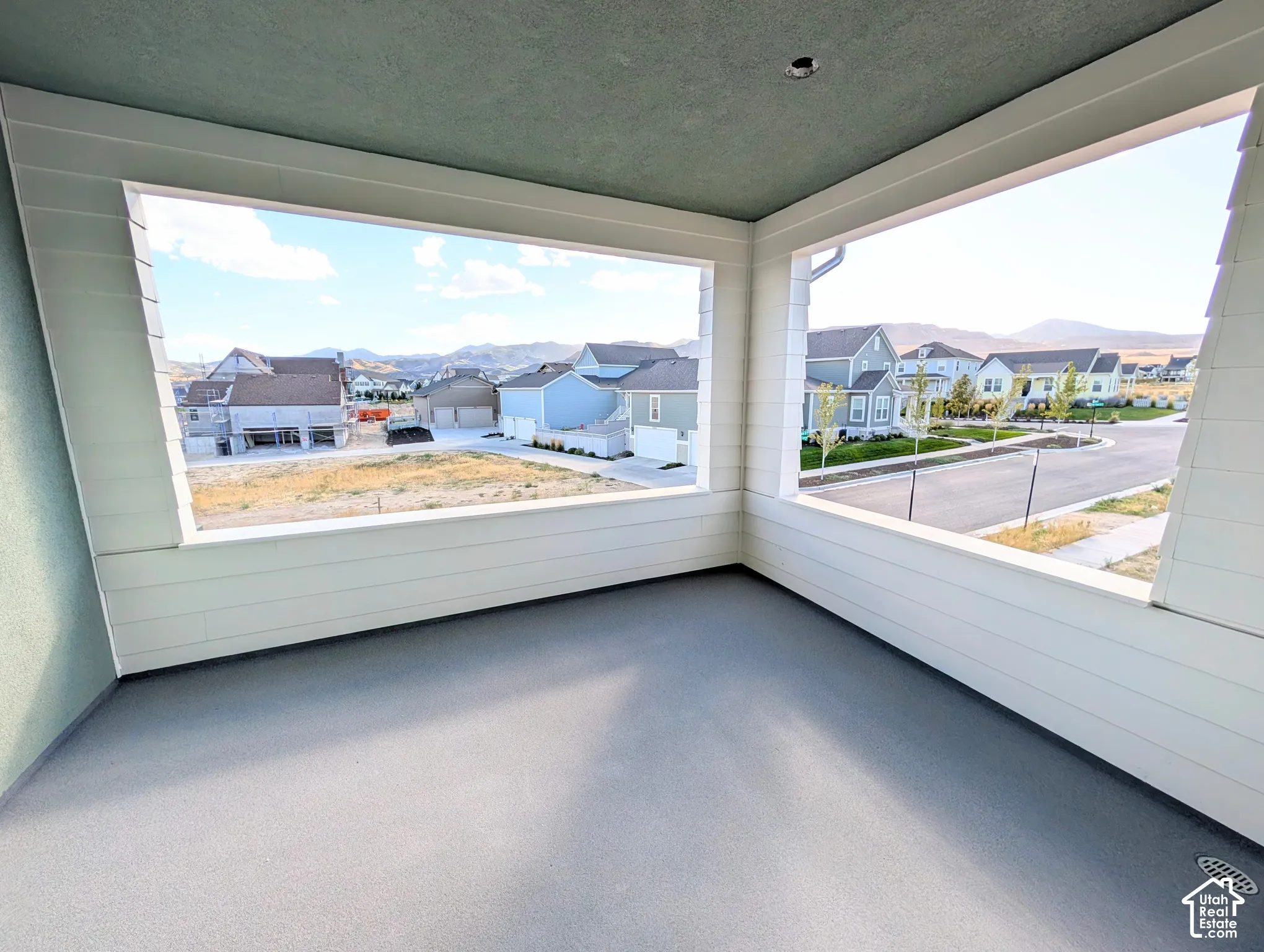 Outdoor covered balcony with a textured ceiling, painted flooring, and white horizontal siding