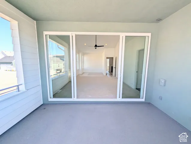 Sliding glass doors opening to a covered patio with painted concrete flooring and painted siding