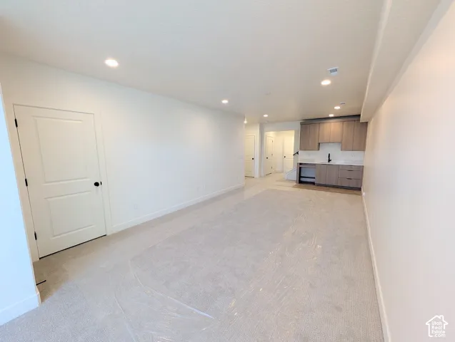 Spacious room featuring neutral carpeting and recessed lighting