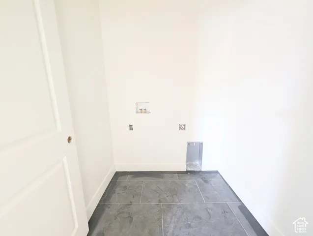 Dark gray tile flooring with white baseboards and white walls