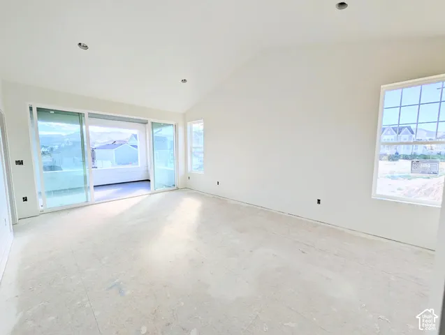 Primary bedroom with Vaulted ceiling, recessed lighting, large window, sliding glass door, and balcony access