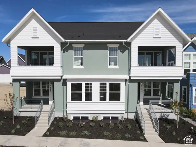 Two-story facade with gabled rooflines and covered entryways