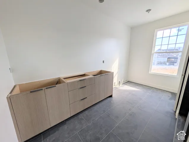 Built-in cabinetry with modern hardware, tiled flooring, recessed lighting, and a large window