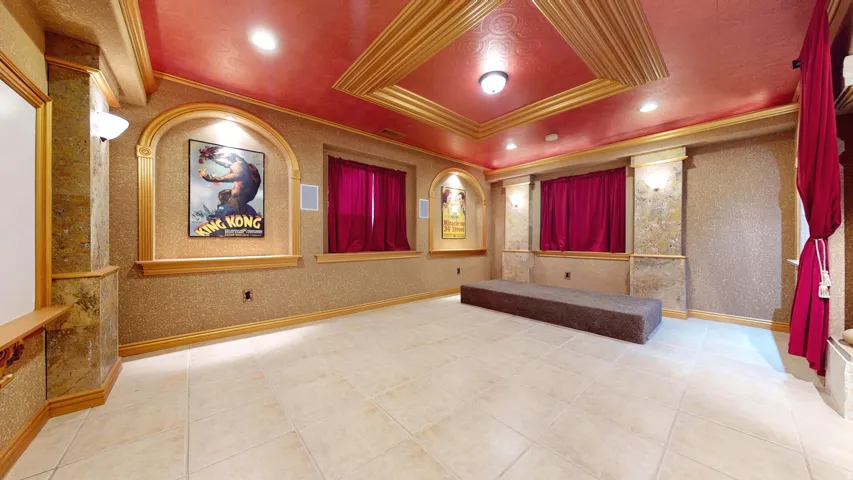 Recessed lighting, tiled flooring, wall sconces, coffered ceiling, and decorative wall panels