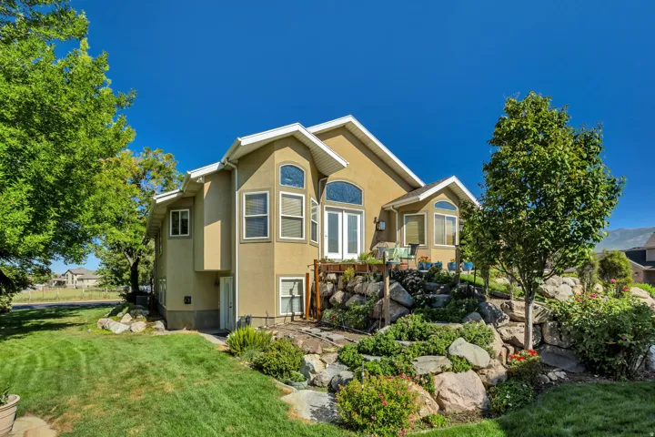 Stucco exterior with multiple arched windows and a terraced rock garden